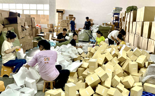 图说:速卖通双11火爆开售,有商家全家上阵打包发货