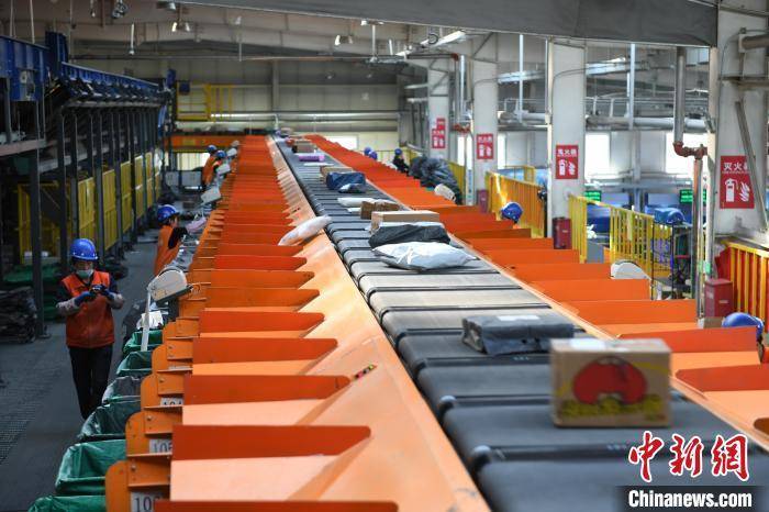 图为10月10日,智能分拣设备将快递包裹在流水线上自动化分拣.