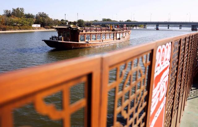 两条代表北京和杭州的游船驶出漕运码头,泛舟大运河之上.