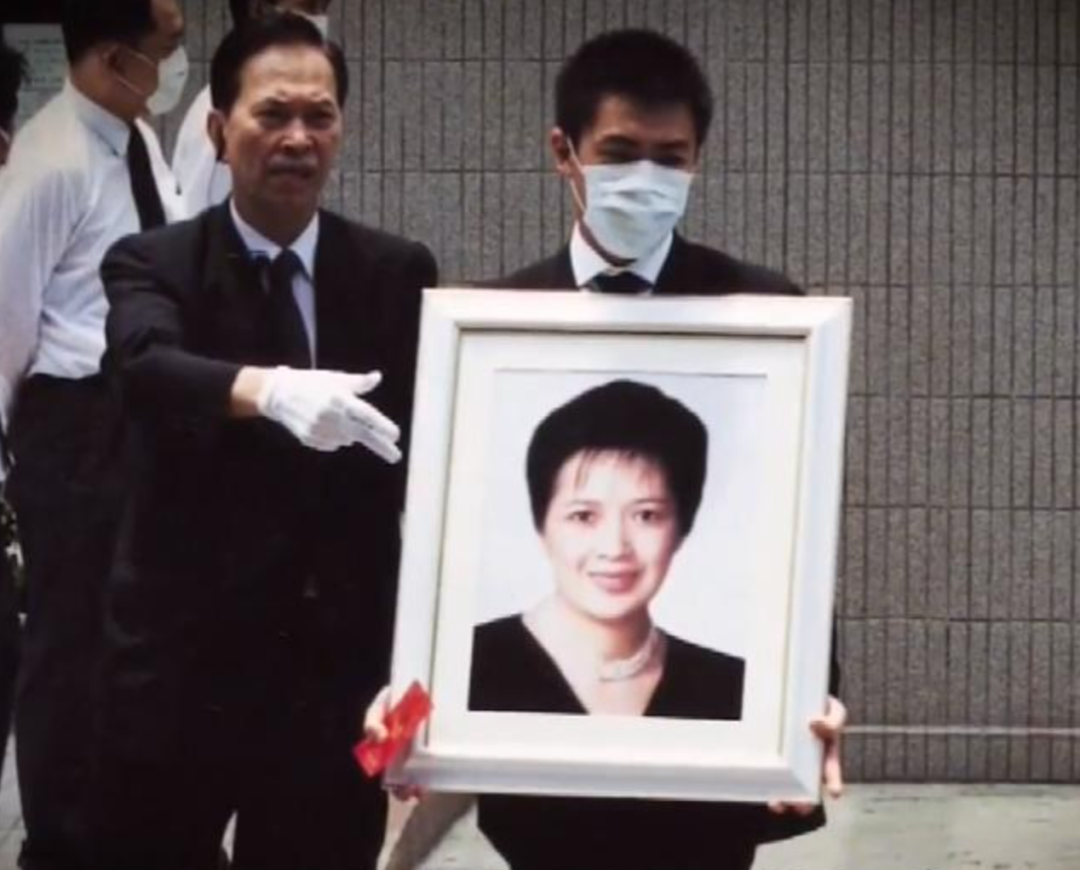 △刘炜鸣捧着母亲遗像