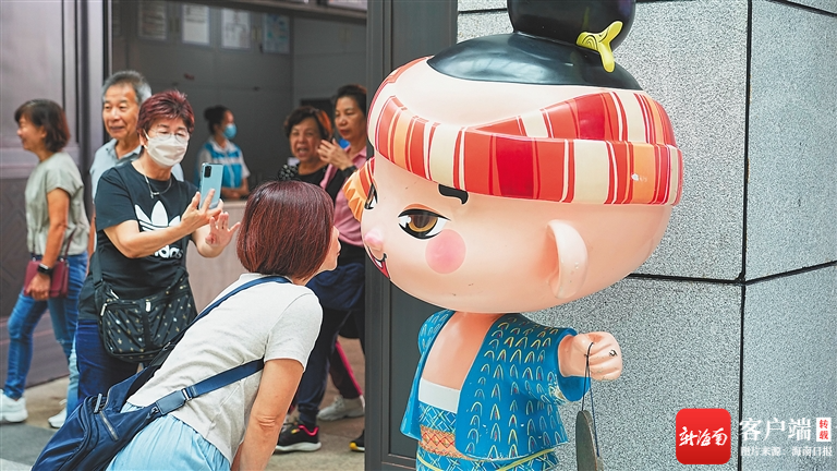 游客与省博物馆原创ip形象"南溟子"合影.海南日报记者 张茂 摄