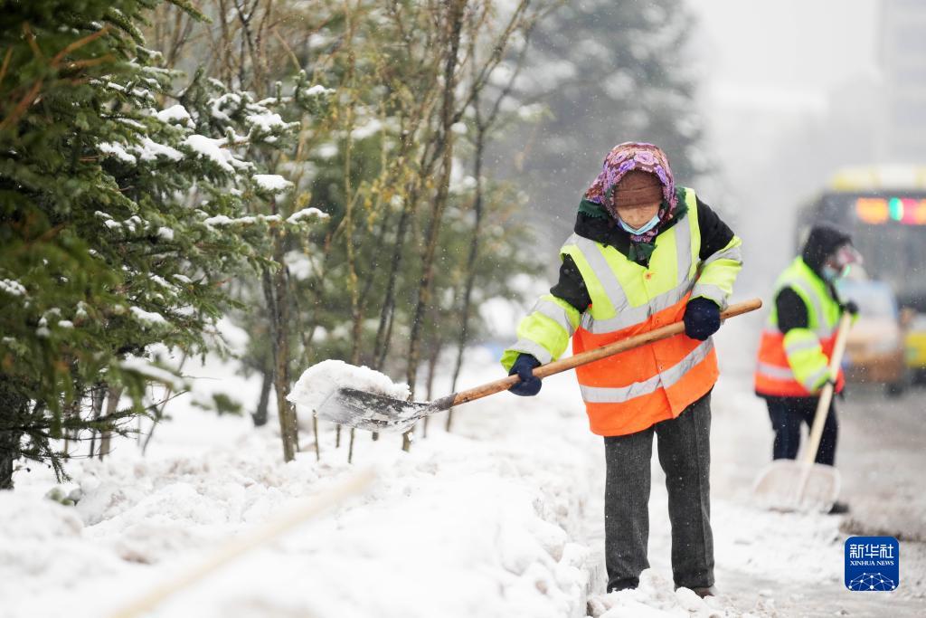11月16日,环卫工人在清理道路上的积雪.