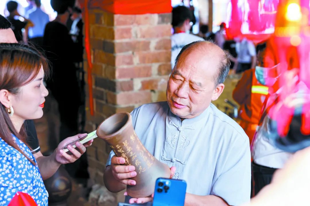 美术大师,国家级非遗代表性传承人李人帡向媒体记者介绍坭兴陶作品