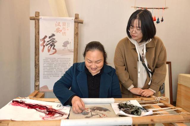 游客在观看市级非遗汉安夏布绣制作(王斌 摄)