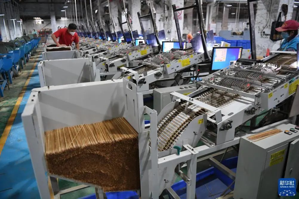 在广宁一家竹制品厂,工作人员在维护竹签自动化生产设备.