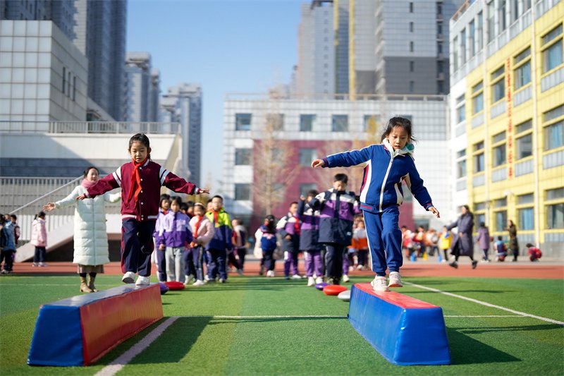 11月17日,河北省唐山市路北区橡树湾小学学生利用课间时间玩平衡木.
