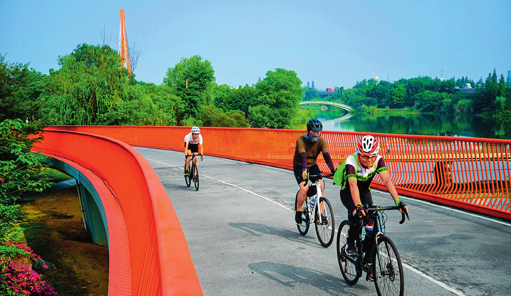 人们在成都锦城湖公园绿道上骑行(2023 年 6 月 25 日摄) 沈伯韩摄