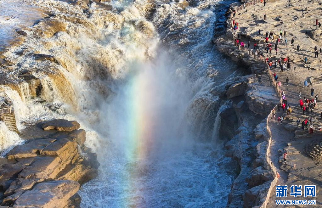 11月16日,众多游客在黄河壶口瀑布景区观赏彩虹.
