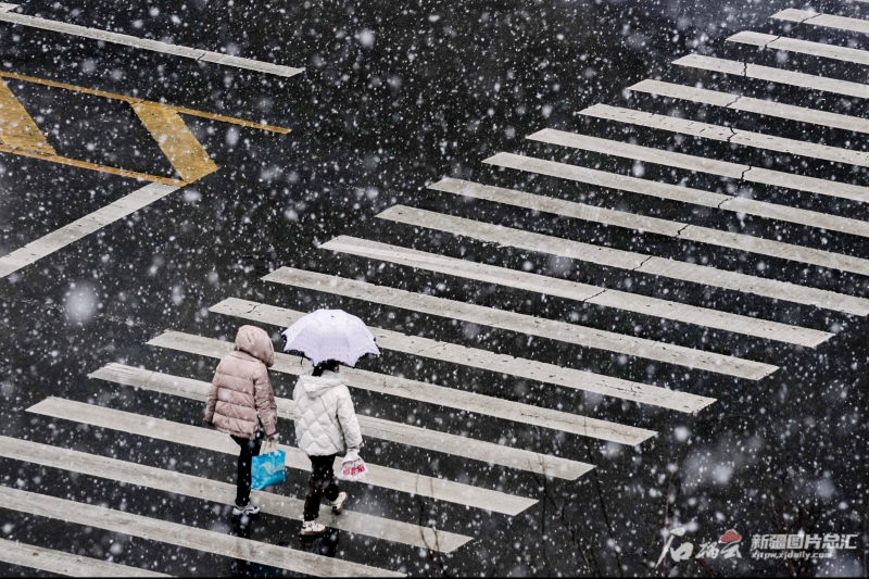 11月20日,乌鲁木齐市水磨沟区八道湾路上行人在过马路.