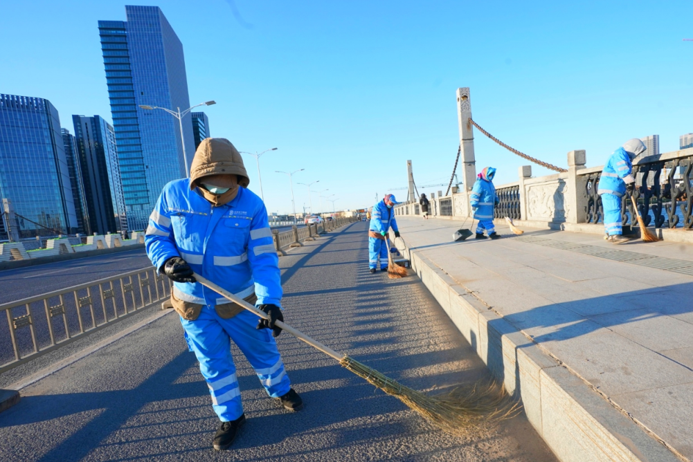 通州区东关大桥,几名北京环卫集团通州京环公司的职工在寒风中进行