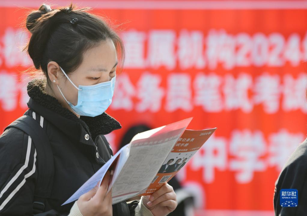 11月26日,在江苏省无锡市清名桥中学考点,一名考生在等候进场时复习.