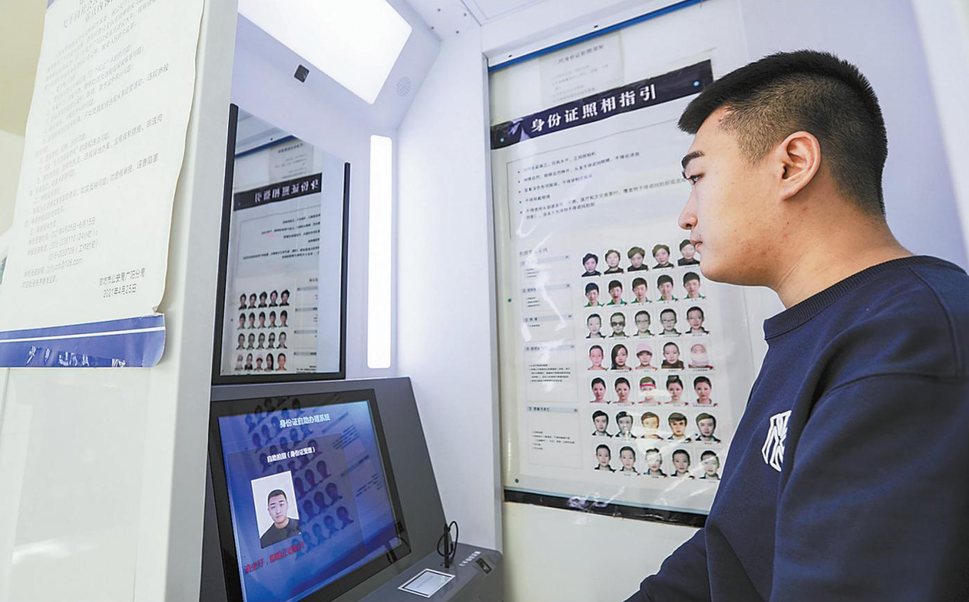 图为在文化艺术中心警务站,市民通过身份证拍照申请一体机办理证件.