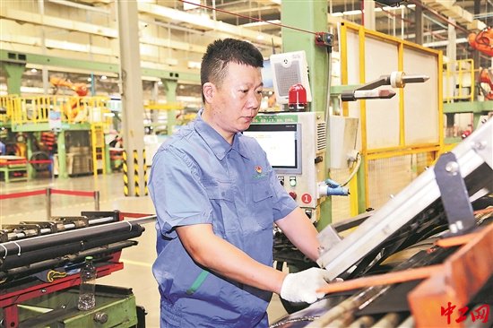 安志成正在"工业4.0"智能化工厂里操作成型机.