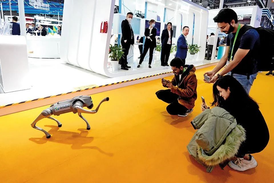 11月7日，在第六届进博会技术装备展区，观众与海克斯康展示的智能机器狗互动