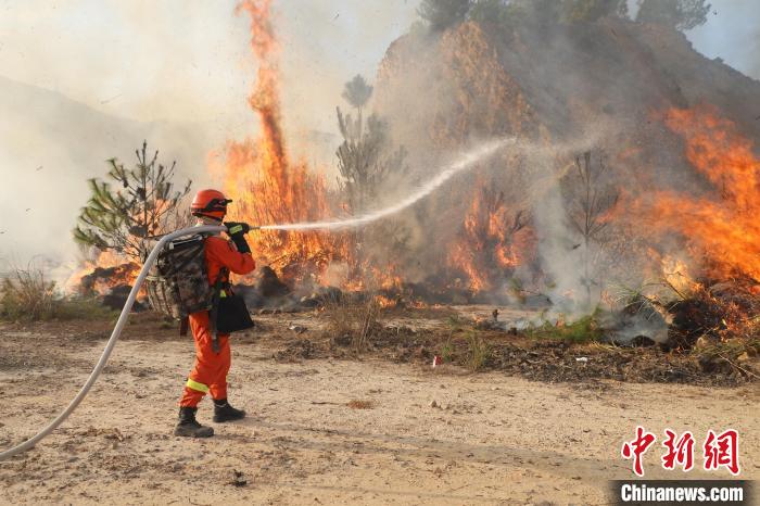 灭火队员肩扛水枪,攻打火头.钟宏斌摄