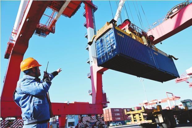 ②在锦州港集装箱码头货场上，码头工人正在指挥吊装集装箱。本报记者 杨靖岫 摄