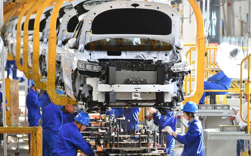 在比亚迪西安草堂工业园区新能源汽车生产车间,工人们正在进行装配