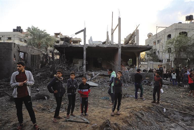 12月1日,人们聚集在加沙地带南部城市汗尤尼斯一处被炸的建筑周围.