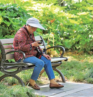 &nbsp;&nbsp;&nbsp;&nbsp;江苏淮安,老人在公园长椅上看手机.