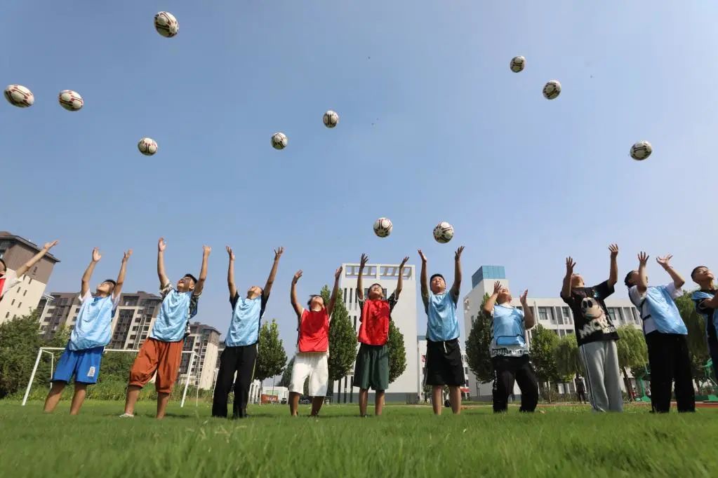 8月31日,河南省焦作市温县第四实验小学学生在体育课上学习足球技能.