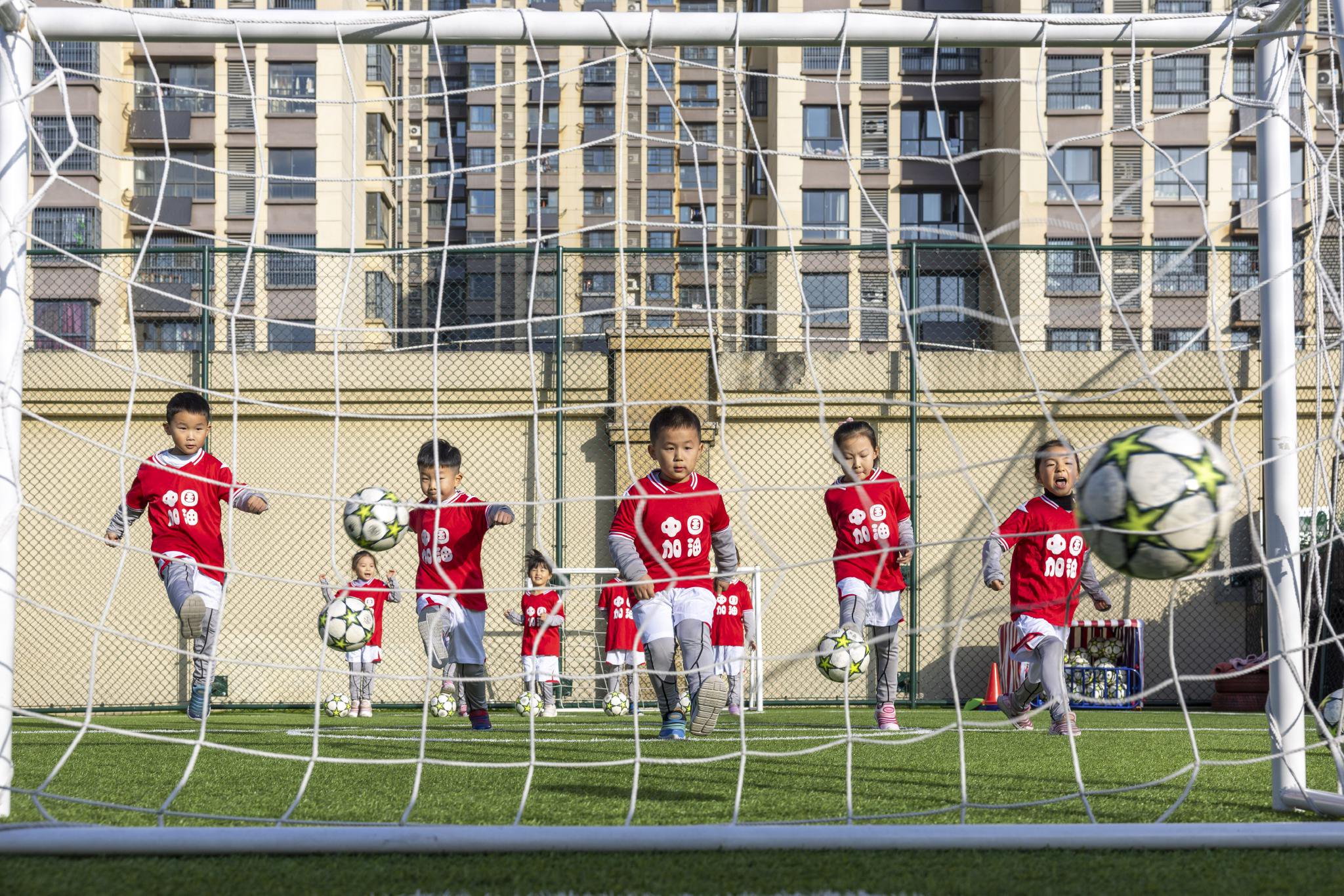 小朋友们正在操场进行足球运动.通讯员 赵明 摄