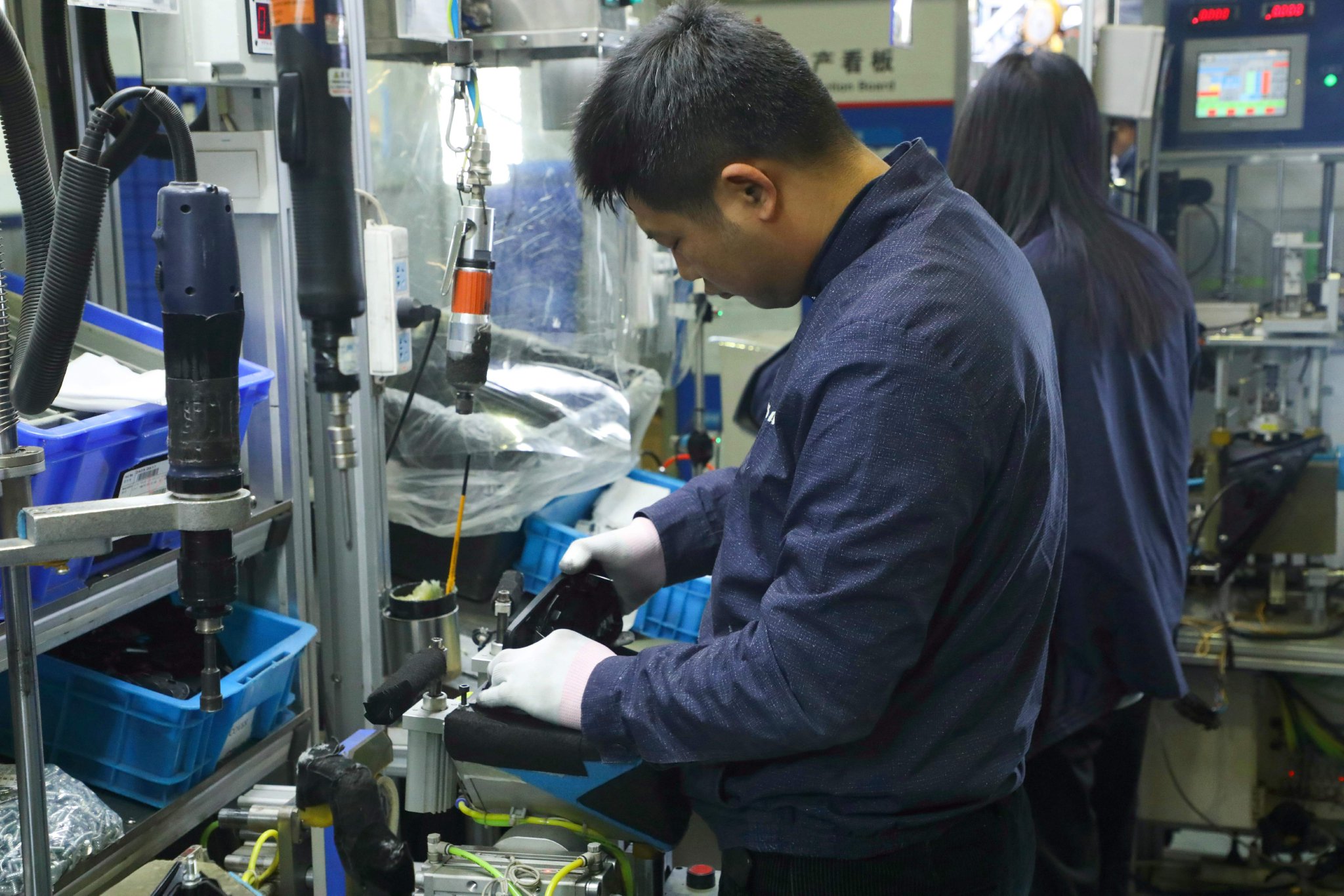 图为在赛铭瑞汽车零部件(廊坊)有限公司生产车间,工人正在组装后视镜.