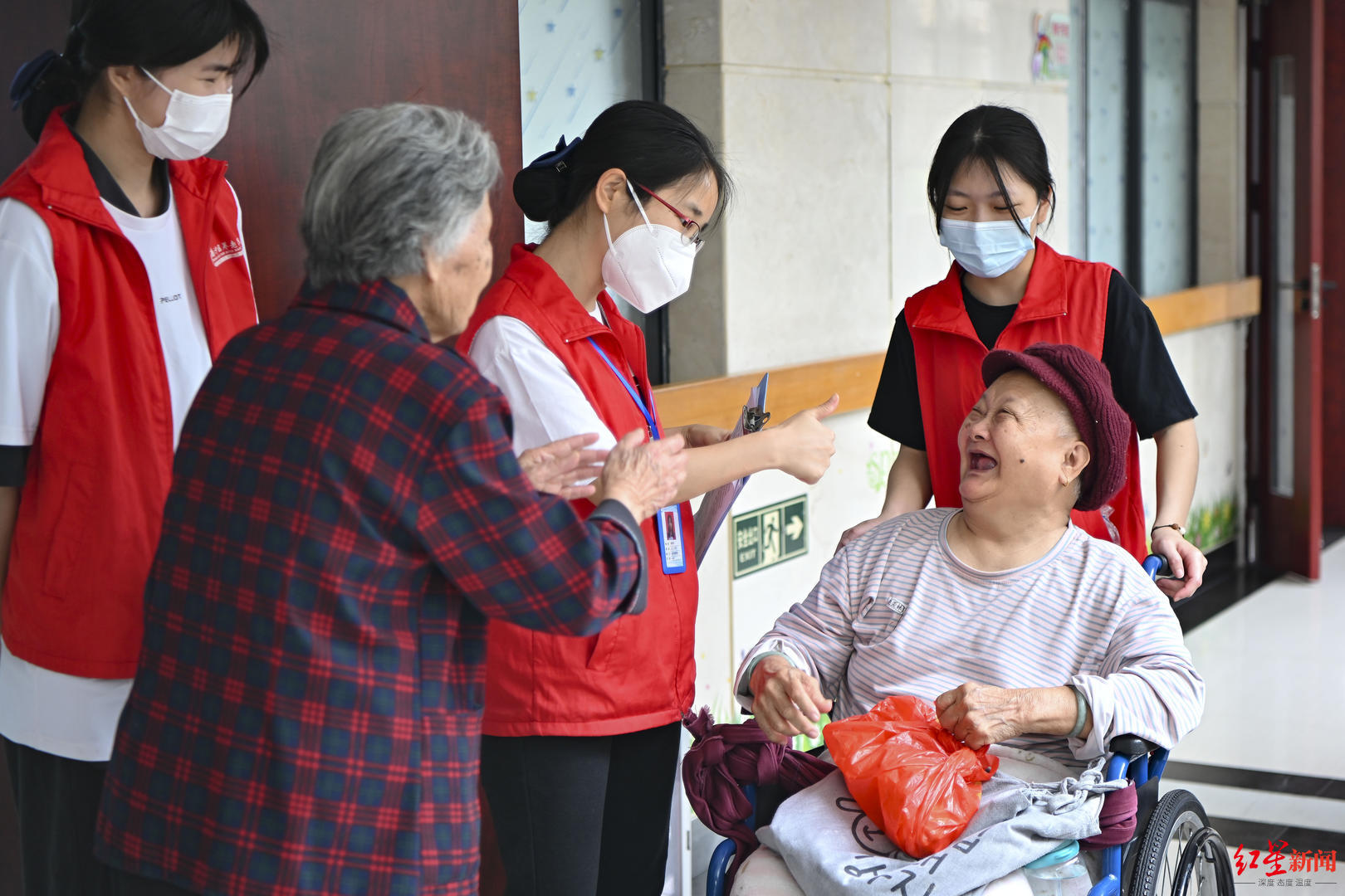 ▲4月12日，广州，工作人员与南沙区养老院的老人聊天。据视觉中国