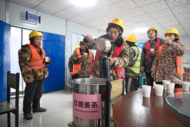 12月12日,在中建二局北方公司天津泰康项目工地,工人在饮用为他们