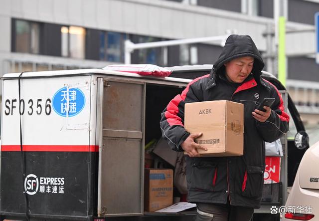 12月12日,在天津市南开区水上公园街道,快递员在派送邮件.