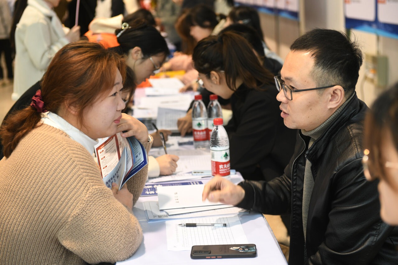 12月8日,大学生求职者在招聘活动现场向用工招聘人员了解招聘信息.