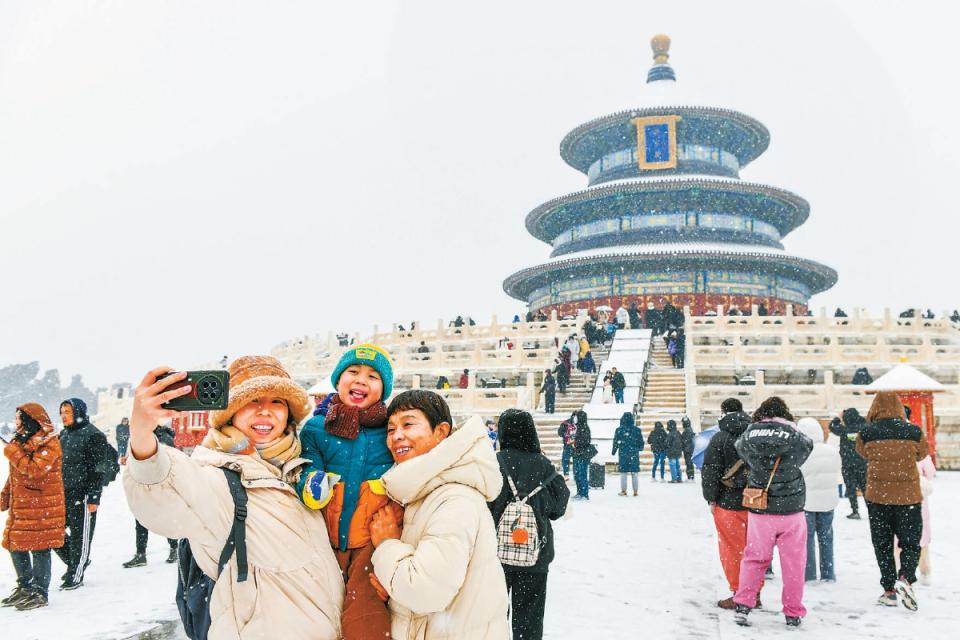 降雪如约而至,天坛祈年殿前,游客在雪中感受北京古都风韵.
