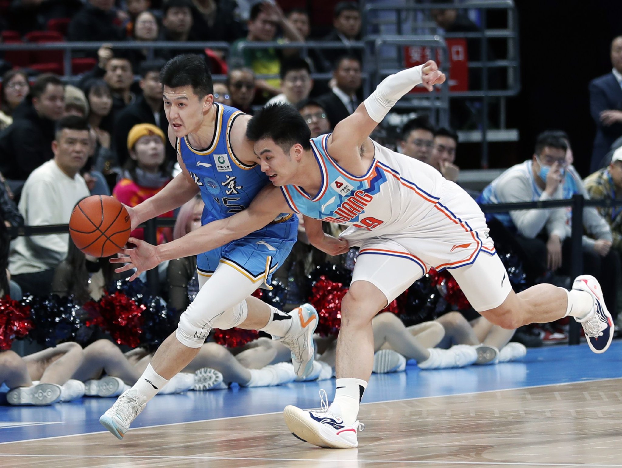 新疆队球员于德豪(右)试图抢断北汽队球员田宇翔. 图/新华社