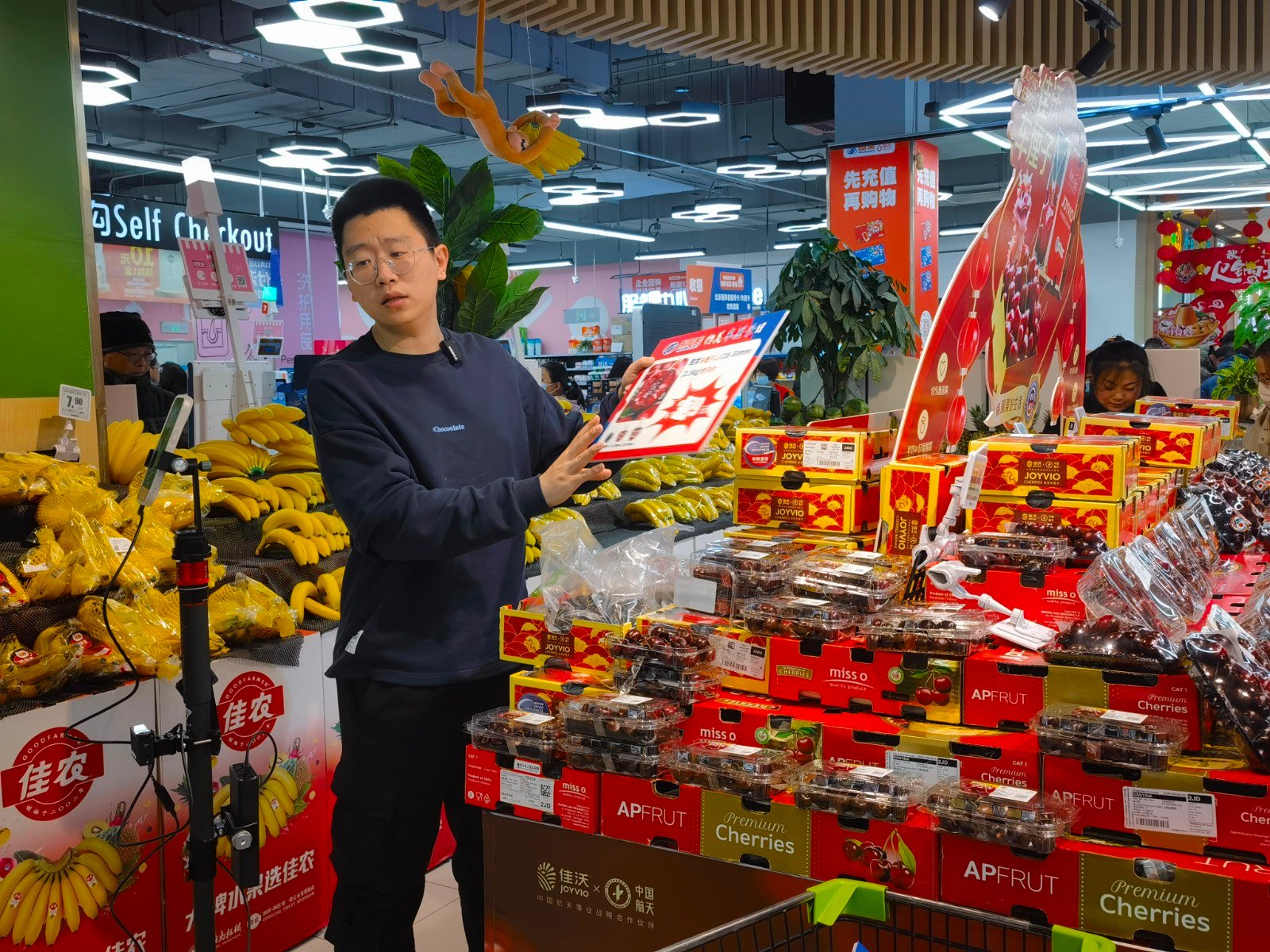 工作人员正在超市直播售卖车厘子.