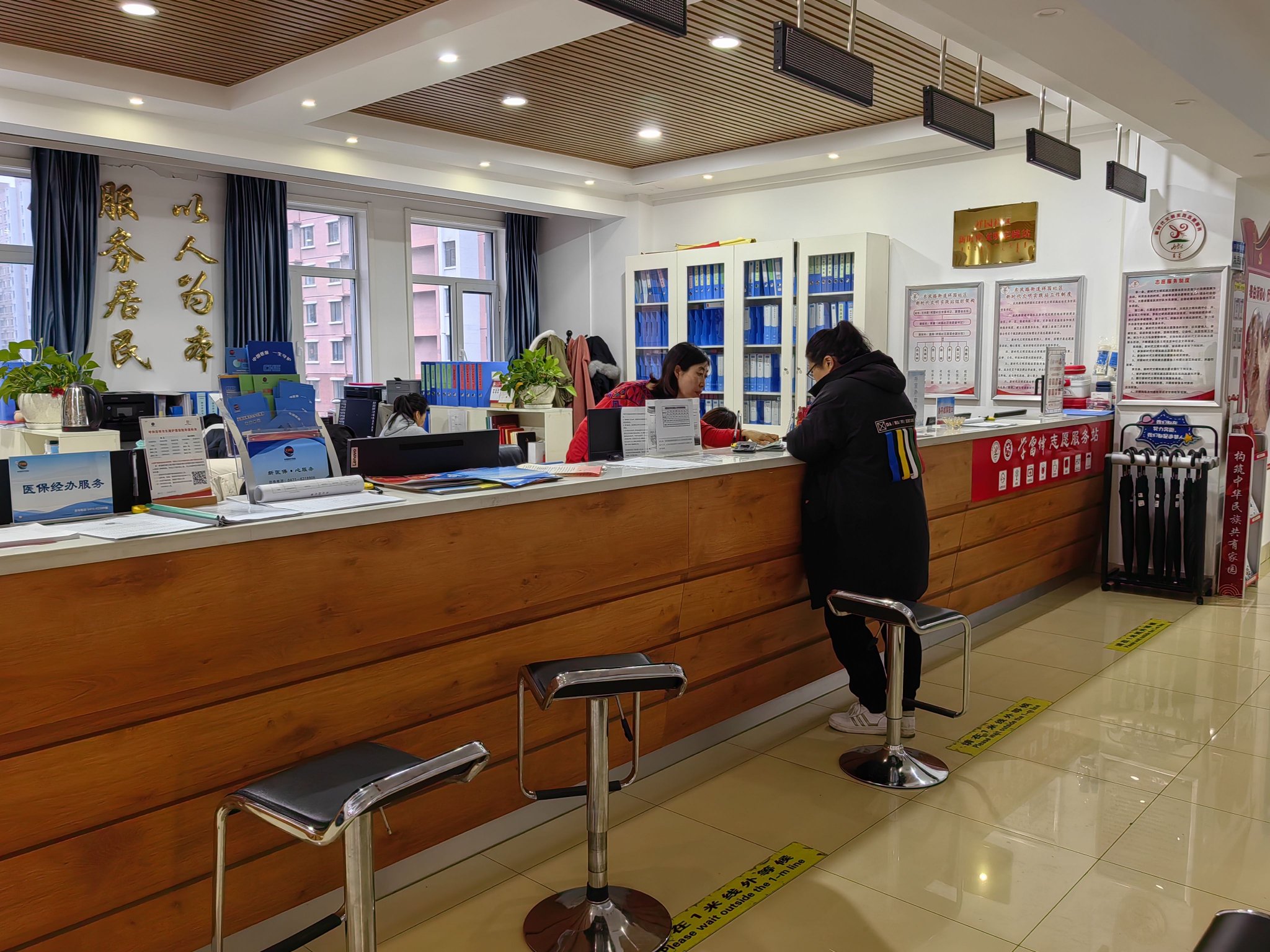 社区新时代文明实践站工作人员帮助居民办理业务