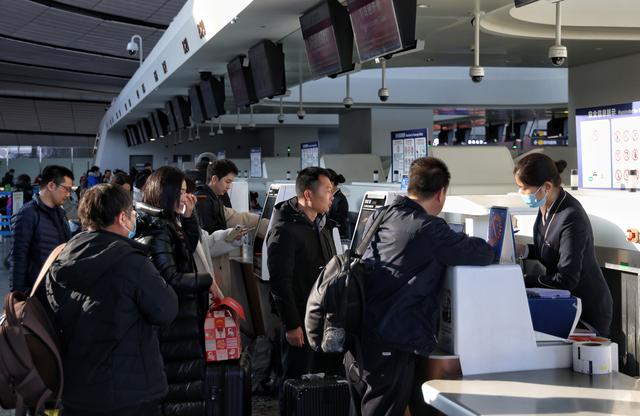12月27日,北京大兴国际机场,旅客在柜台办理值机手续.
