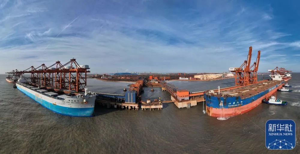 12月26日，一艘轮船（右）在唐山港曹妃甸港区矿石码头卸载后准备离港（无人机全景照片）。