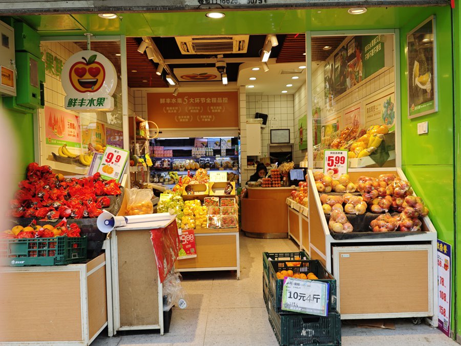一家鲜丰水果店里使用暖黄光照射水果.