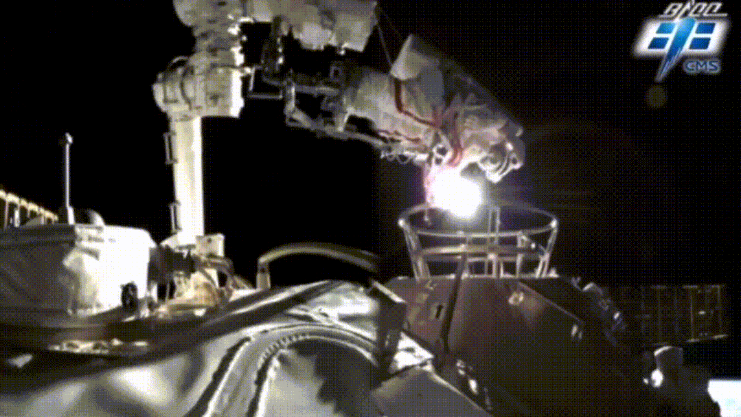 △航天员在机械臂辅助下开展舱外活动