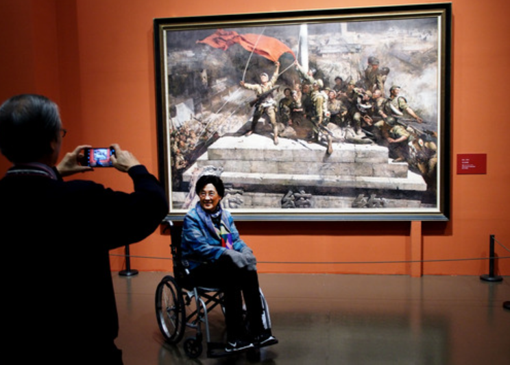 观众在陈逸飞和魏景山合作的画作《攻占总统府》前留影。新华社记者 任珑 摄