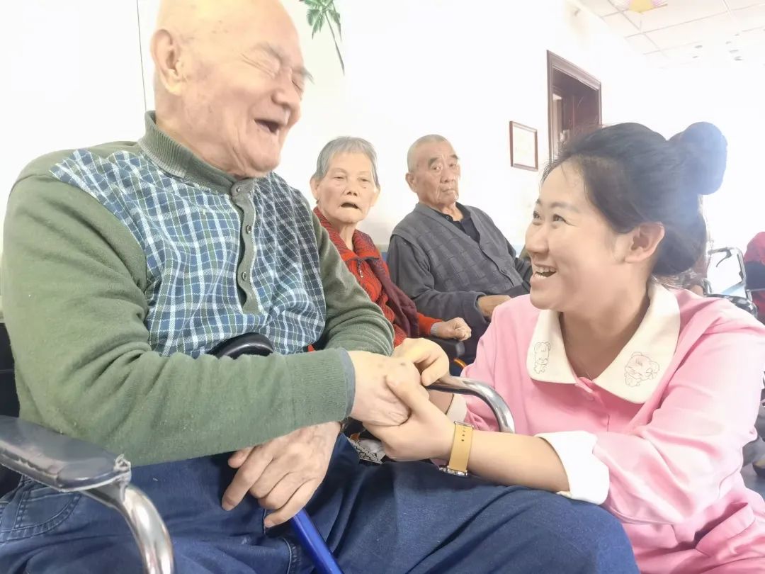 养老机构护理人员与老人谈心.