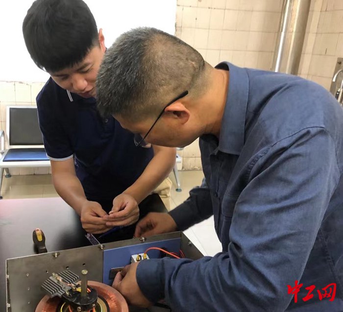 图为电气专家和青年员工在安装检测装置. 魏小兵 摄