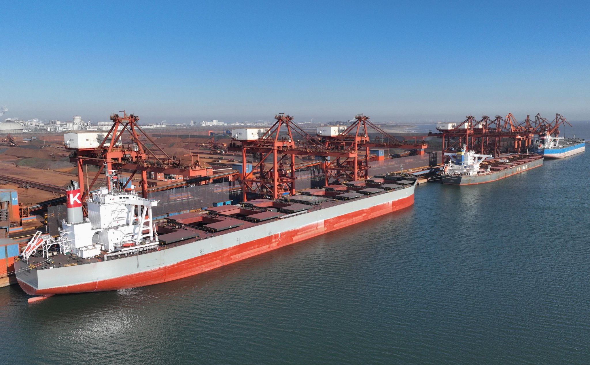 1月15日，三艘轮船靠泊在唐山港京唐港区矿石码头卸载货物(无人机照片)。 新华社记者 杨世尧 摄