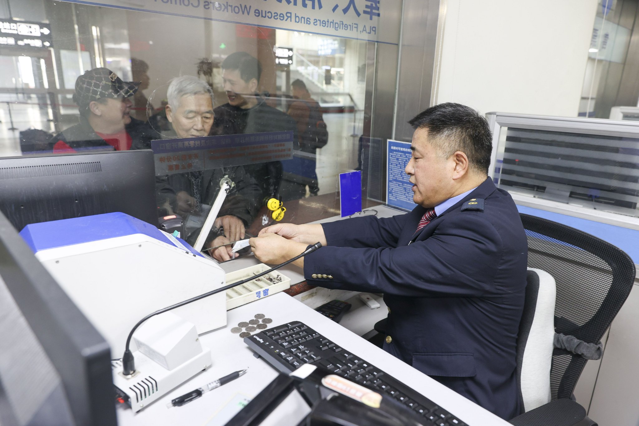 1月12日,春运火车票开始发售,旅客在南京火车站售票大厅通过售票窗口