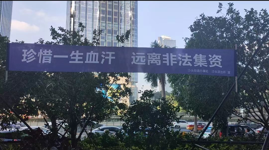 鼎益丰深圳办公场所楼下横幅（记者拍摄）