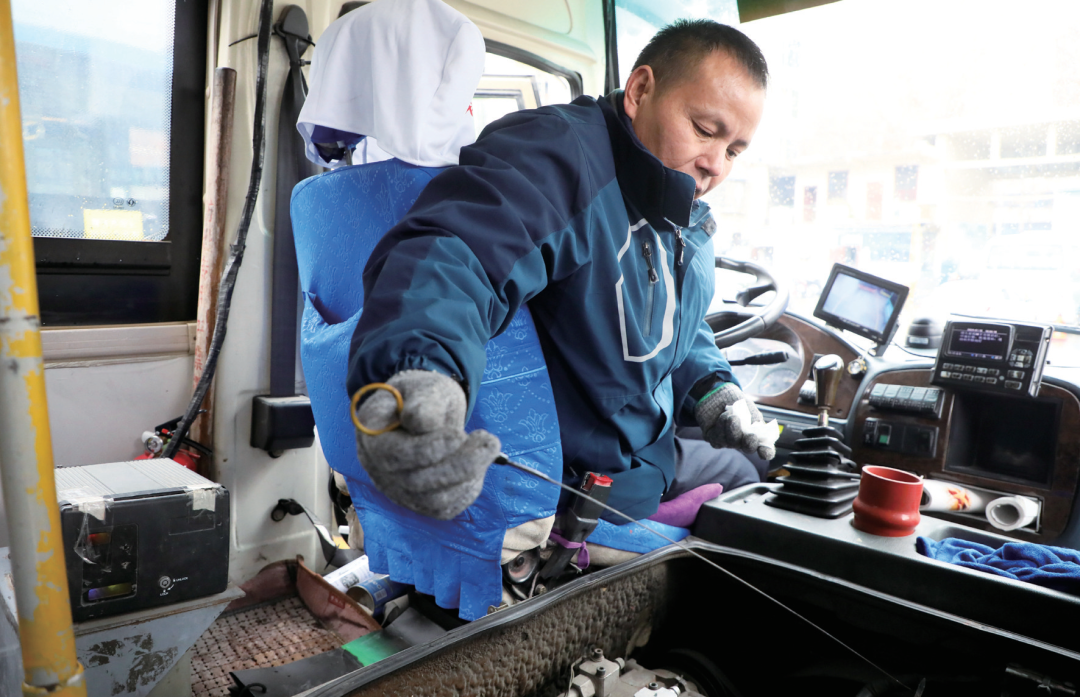 出车前,王付先检查62路公交车安全状况.