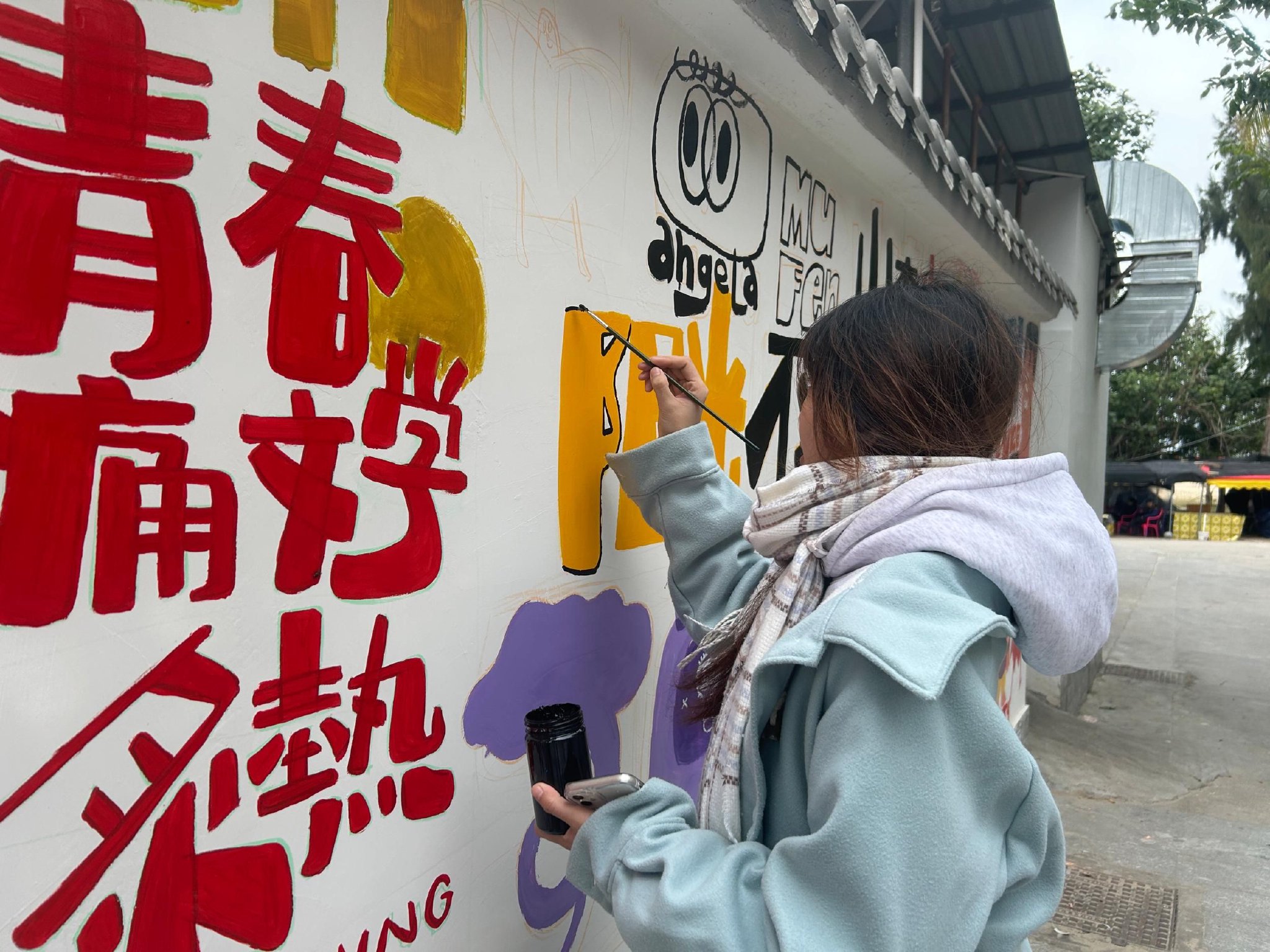 返乡大学生在画墙绘.李锦薇供图