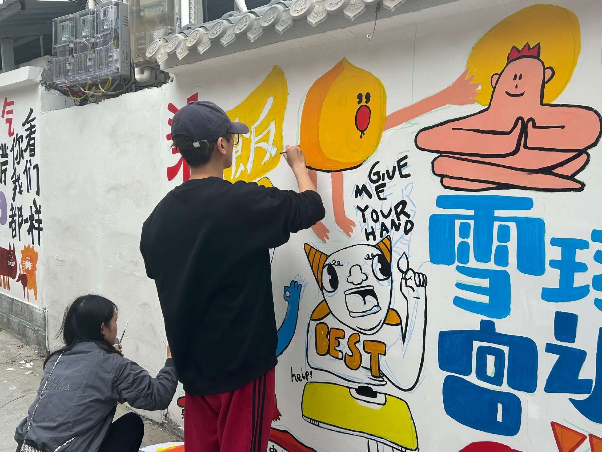 返乡大学生在画墙绘.李锦薇供图