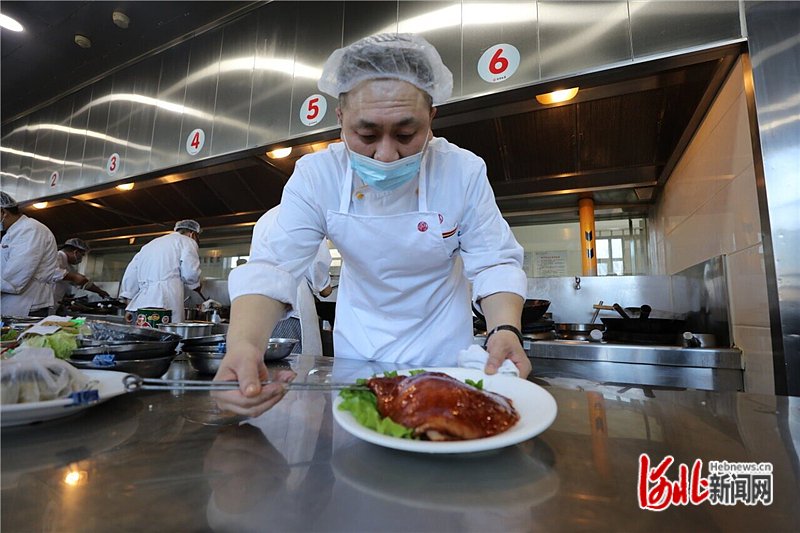 1月24日中午,在唐山鸿宴饭庄后厨,厨师把做好的"崇礼菜单"菜品"鸿宴