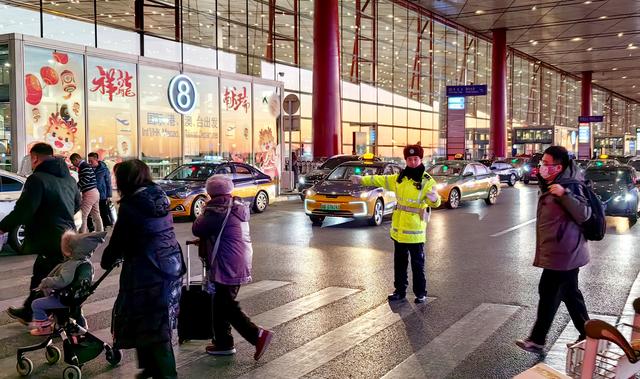 首都国际机场分局交通警察支队民警在航站楼前疏导早高峰车辆和旅客。图源：首都机场公安分局