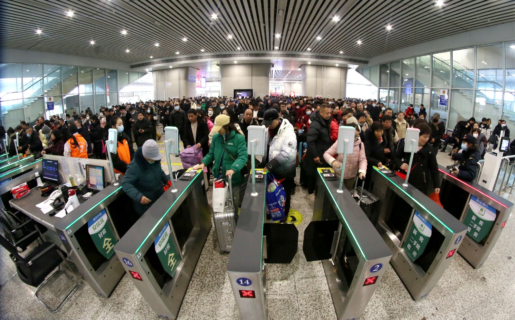 2024年1月26日，旅客在江苏常州北站通过自动检票机。新华社发（陈暐摄）